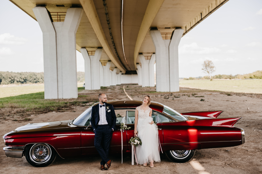 czerwone cabrio, auto do ślubu, fotografia ślubna kraków, para młoda przed autem, 