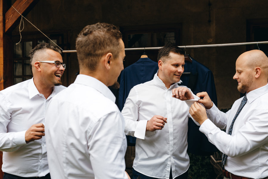 drużbowie i przyjacie pomagają panu młodemu zapiąć spinki przy koszuli, fotografia ślubna Dobczyce