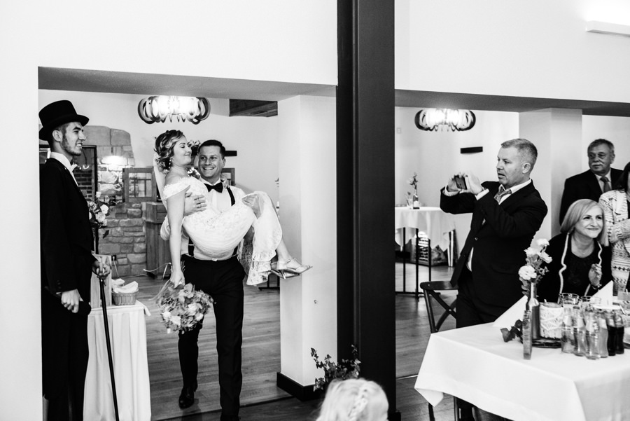 pan młody wnosi żonę na rękach przez próg, dwór kociołek wesele