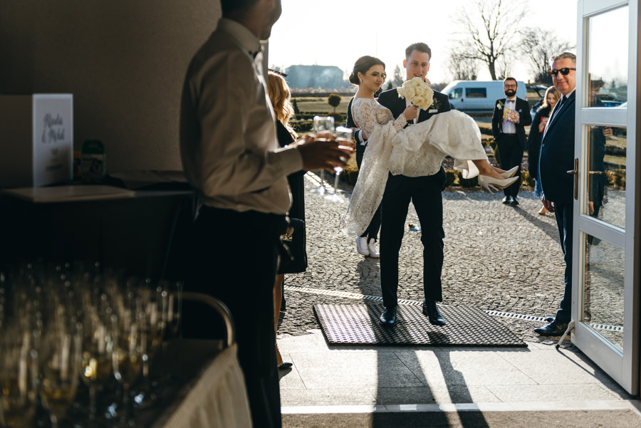 pan młody przenosi żonę przez próg, Hotel Panorama Garden, wesele, reportaż ślubny, Fotograf Bochnia