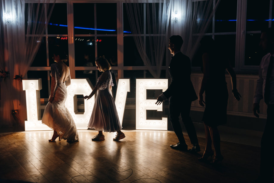 napis love ze światełek, sylwetki tańczących ludzi, hotel panorama garden wesele